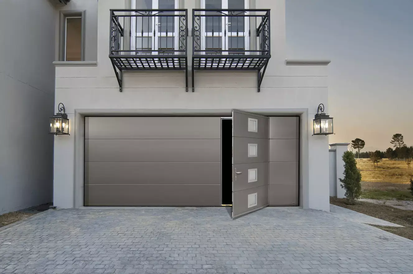 Porte de garage grise avec porte d'entrée sur le coté